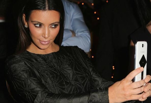 Taking a selfie with a Samsung, smooth Kim K.