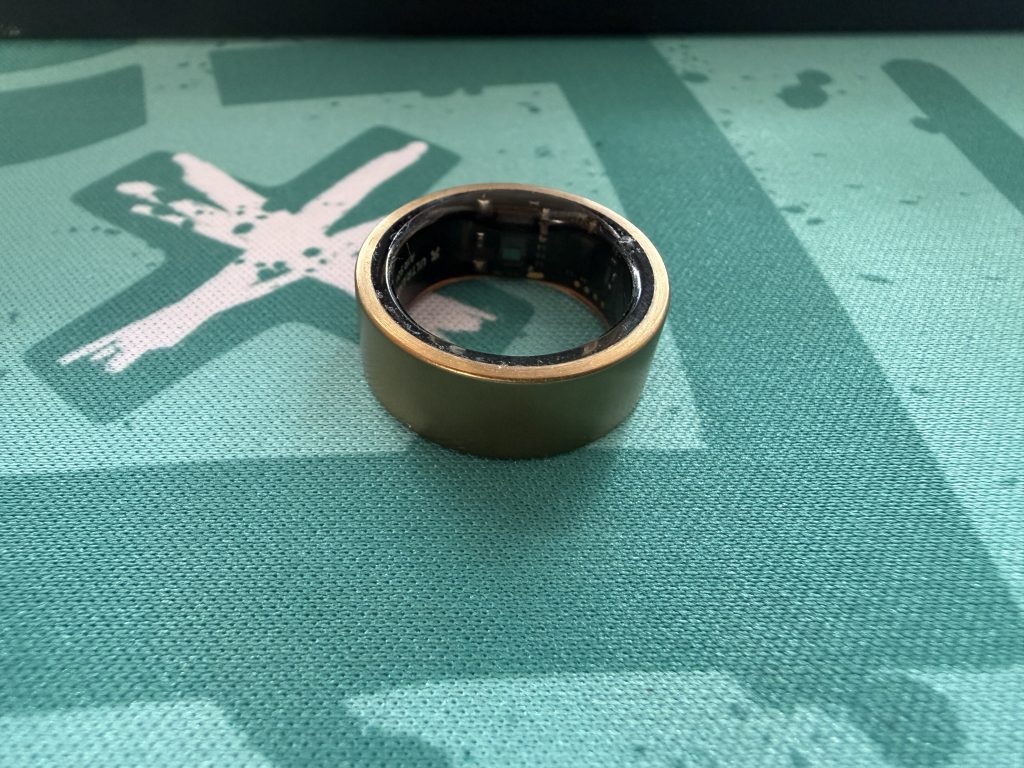 Ultrahuman Ring Air smart ring in Brushed Rose Gold finish sitting on a neutral background