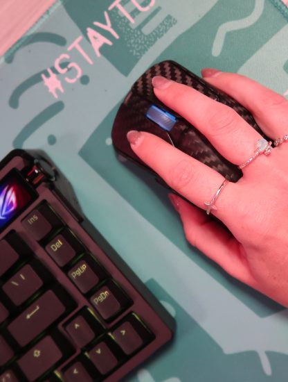 TechGirlZA holding the ROG Harpe Ace Extreme, showing its real carbon fibre shell.