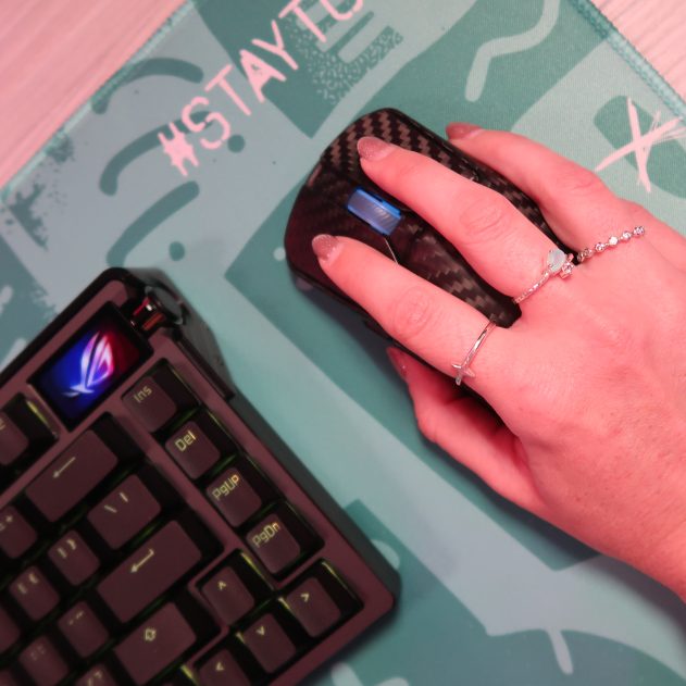 TechGirlZA holding the ROG Harpe Ace Extreme, showing its real carbon fibre shell.