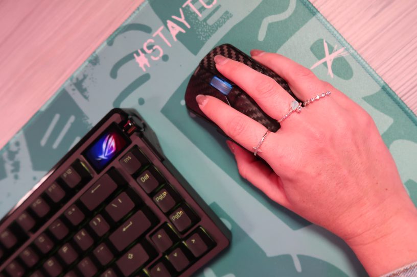 TechGirlZA holding the ROG Harpe Ace Extreme, showing its real carbon fibre shell.